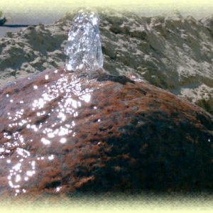 Roter       Granit- Quellstein auf beigem Zierkies in Livorno-Becken (Größe  80/80/35       cm)